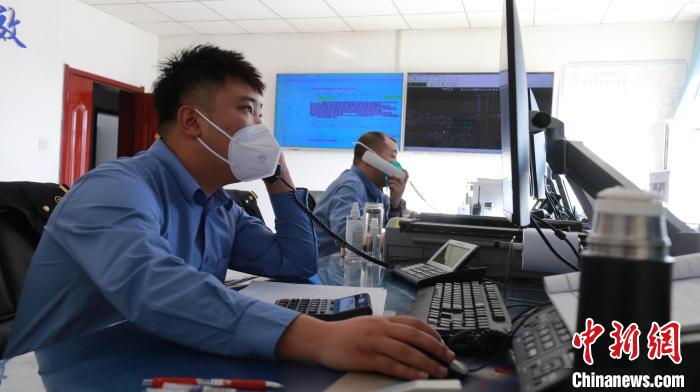 圖為貨運(yùn)調(diào)度人員與外勤工作人員聯(lián)系掌握車輛裝載情況?！±钌?攝