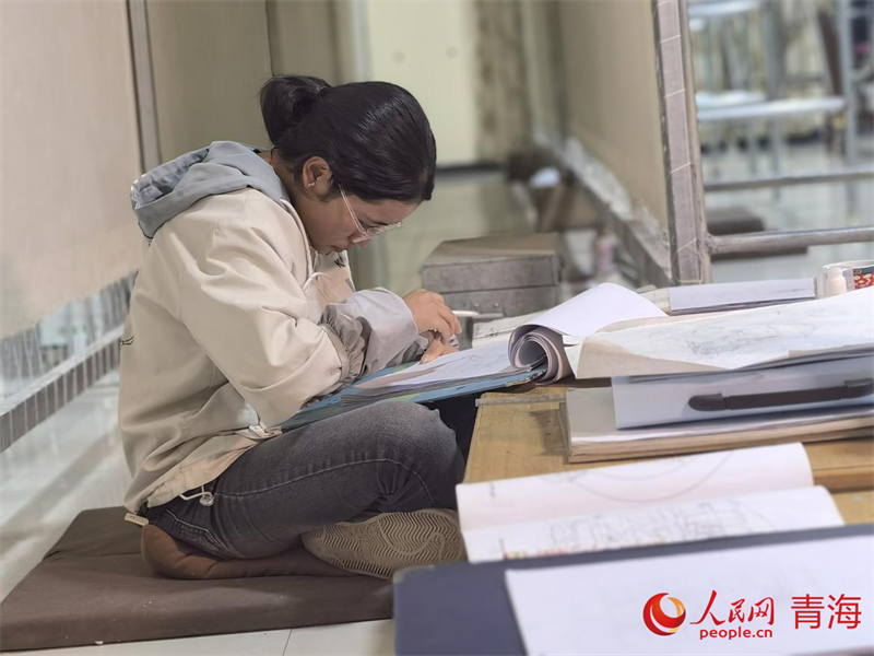 正在學(xué)習(xí)畫(huà)底稿的尕讓旺姆。人民網(wǎng) 陳明菊攝