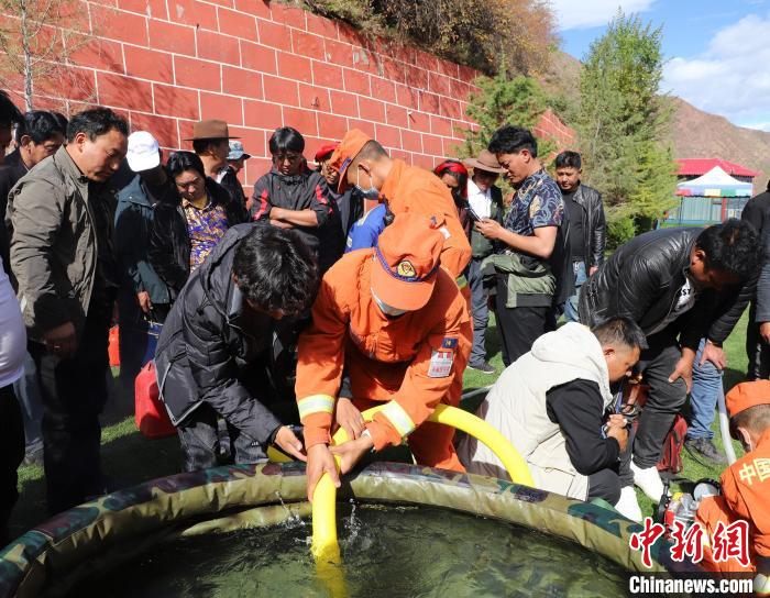 圖為森林消防員為護(hù)林員講解滅火裝備的使用方法。　昌都市森林消防支隊(duì) 供圖