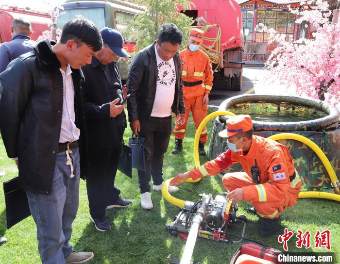 圖為森林消防員為護(hù)林員講解滅火裝備的使用方法?！〔际猩窒乐ш?duì) 供圖