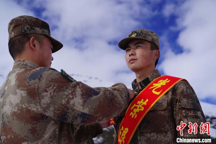 排長(zhǎng)王朝偉(圖左)給退伍老兵佩戴大紅花。　西藏山南軍分區(qū)某團(tuán)供圖