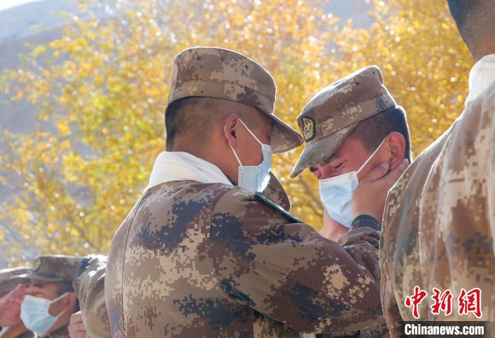 圖為什布奇邊防連退伍老兵與戰(zhàn)友相擁而泣，依依惜別。　徐昌成 攝