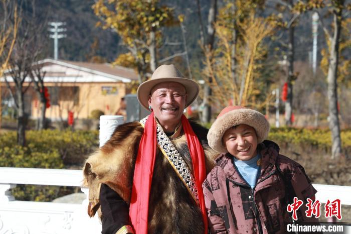 圖為林芝市巴宜區(qū)布久鄉(xiāng)仲果村村民桑杰與孫子一起參加藏歷新年活動?！埩?攝