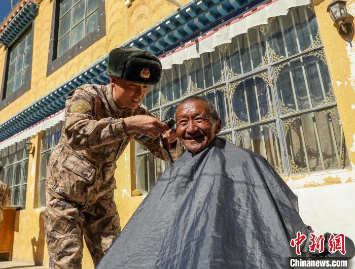 圖為阿里軍分區(qū)某邊防團官兵為駐地群眾理發(fā)迎藏歷新年。　旦增倫珠 攝