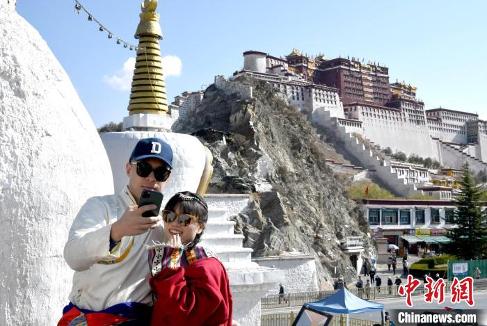4月17日，游客身著藏式元素服裝在拉薩布達(dá)拉宮觀景臺(tái)拍照留念?！±盍?攝