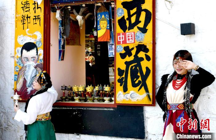 4月17日，游客身著藏式元素服裝在拉薩八廓街拍照留念?！±盍?攝