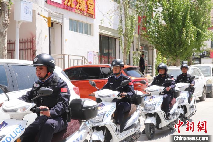 民警騎著電瓶車在轄區(qū)巡邏走訪。　黃創(chuàng)偉 攝