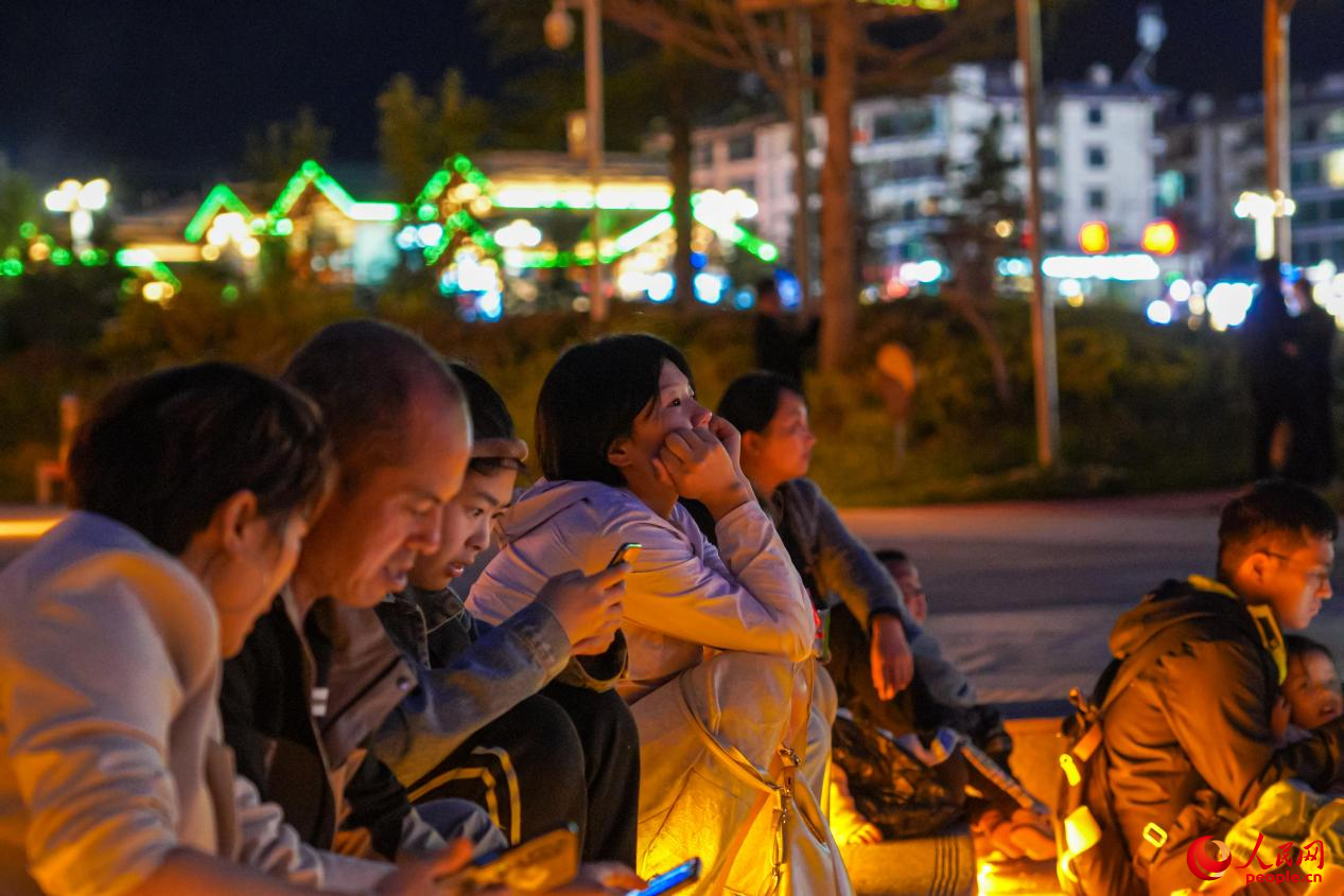 市民坐在西藏林芝市民族團結廣場臺階上欣賞音樂噴泉。人民網(wǎng)記者 趙晨攝