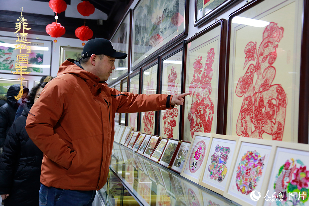 2025年1月23日，游客在天津楊柳青古鎮(zhèn)欣賞傳統(tǒng)剪紙作品，感受指尖上的古老藝術(shù)。人民網(wǎng)記者 崔新耀攝