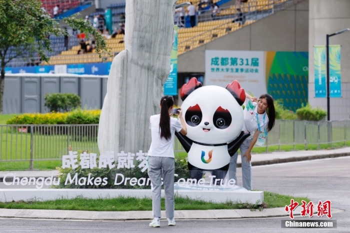 志愿者在比賽場(chǎng)館外與吉祥物景觀合影。<a target='_blank' href='/'><p  align=